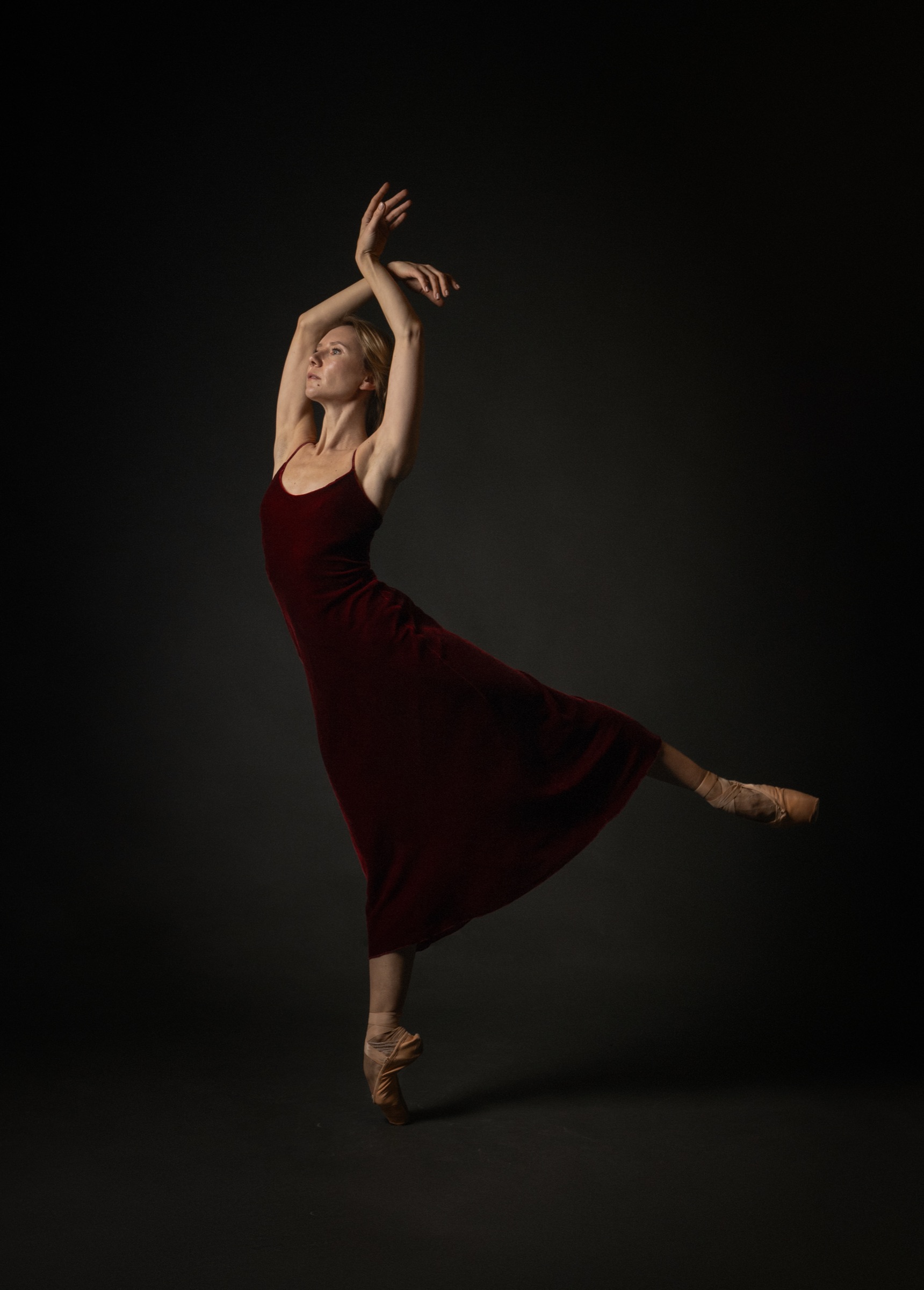 Anastasia Kurkova in arabesque in a dark red velvet dress
